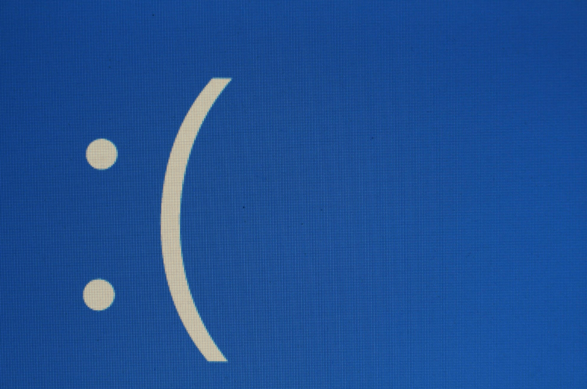 Sad face emoticon illustrating concerns about self-driving car safety and technical errors.